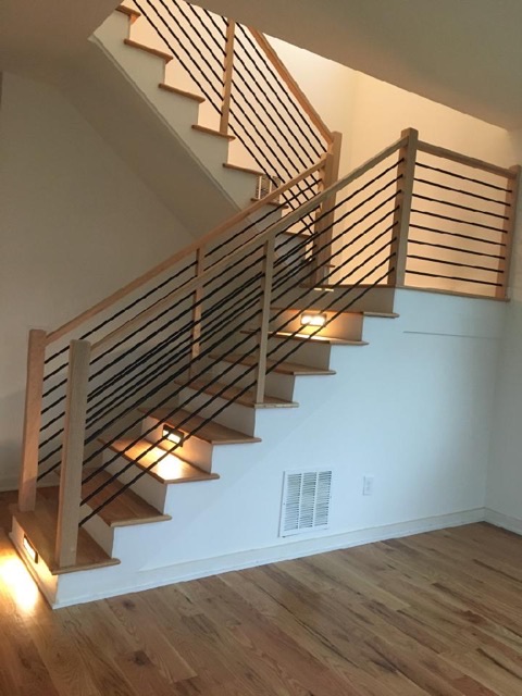 Modern staircase with horizontal slat railing and integrated step lighting