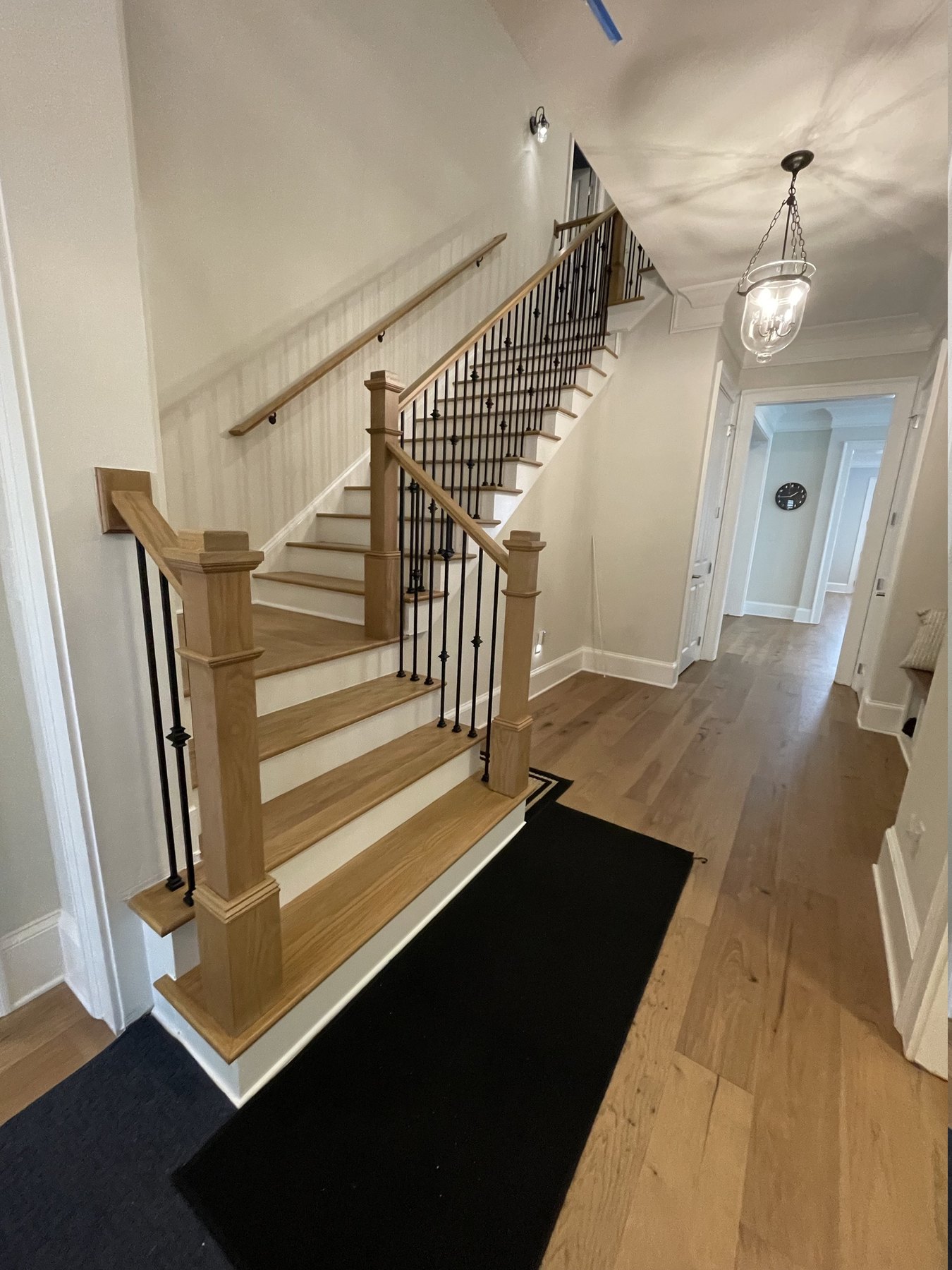 Alpharetta, GA staircase after remodeling &mdash; white oak treads, painted risers, square newel posts and iron balusters