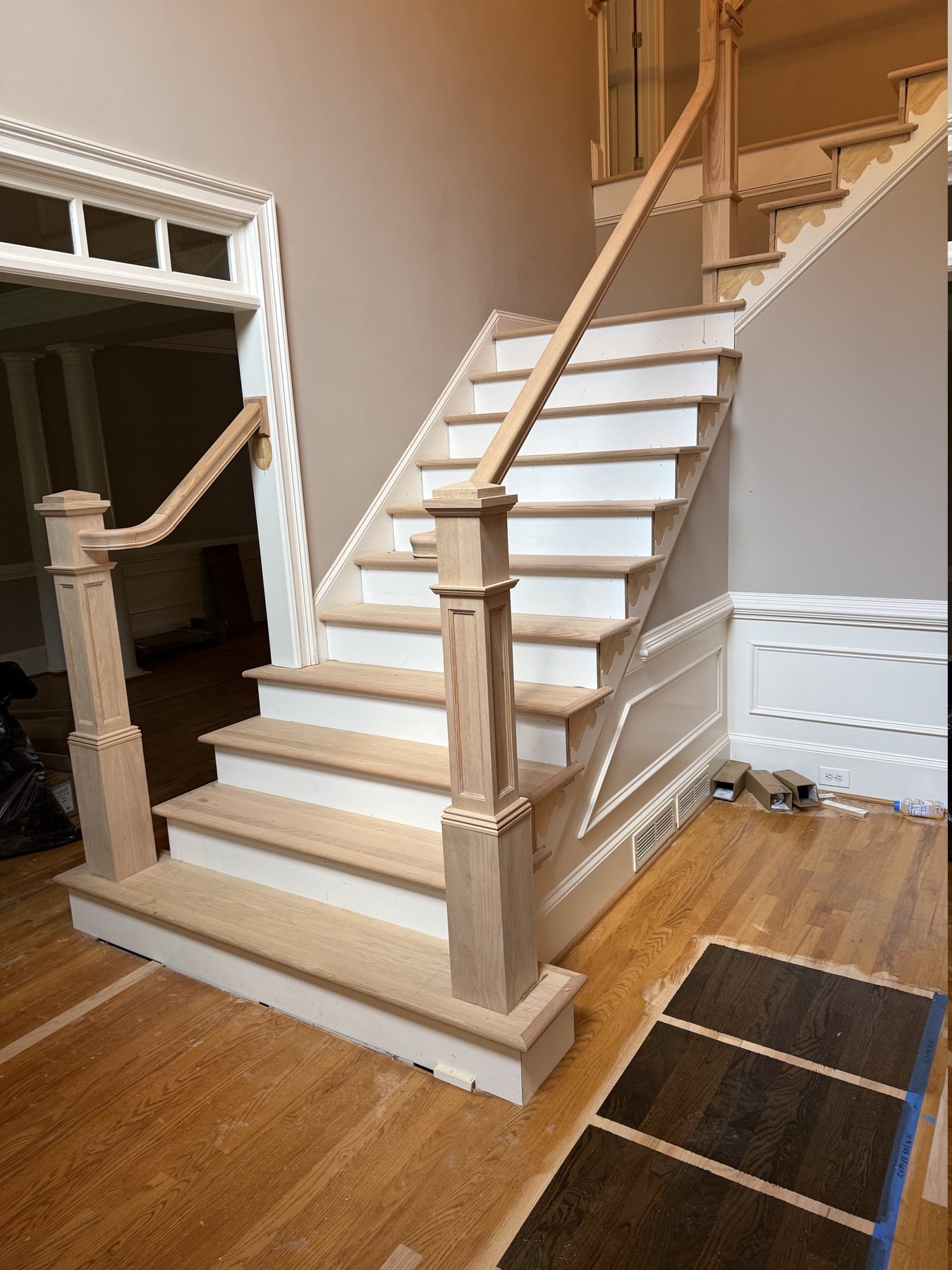 Alpharetta, GA staircase mid-remodel &mdash; carpet removed, bare oak treads over painted risers, square box newel posts and new handrail